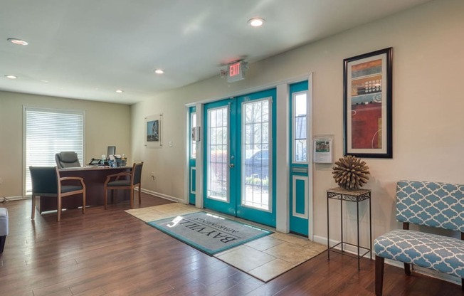 a living room with turquoise doors and a table with chairs at Bayville Apartments, Virginia Beach, Virginia