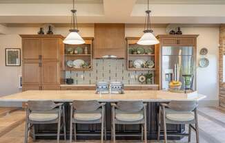 A kitchen with a table and chairs in front of it.