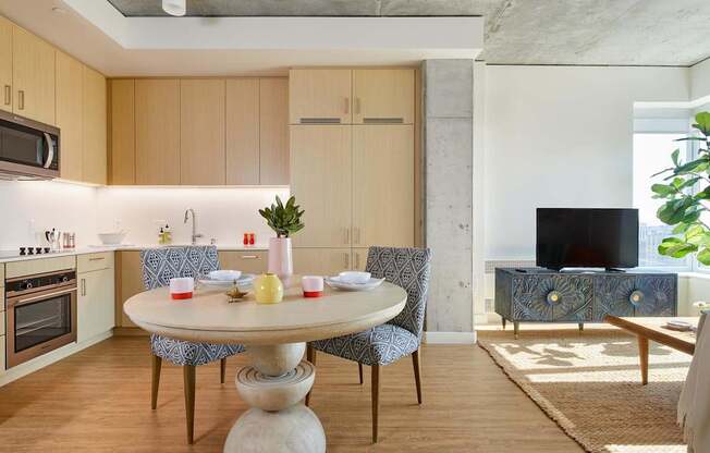 A modern kitchen with a round table and chairs.