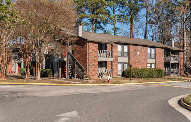 A red brick building with a grey roof and a white fire hydrant in front.