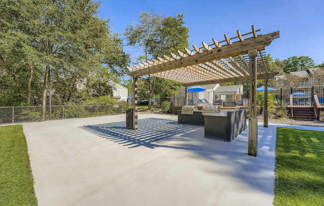 A playground with a wooden pergola and concrete structures.