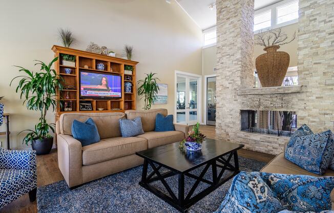 A living room with a tan couch and a black coffee table.
