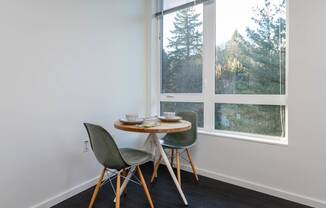 a small table with two chairs in front of a window