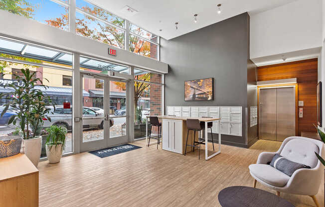 A modern office lobby with a chair, desk, and potted plant.