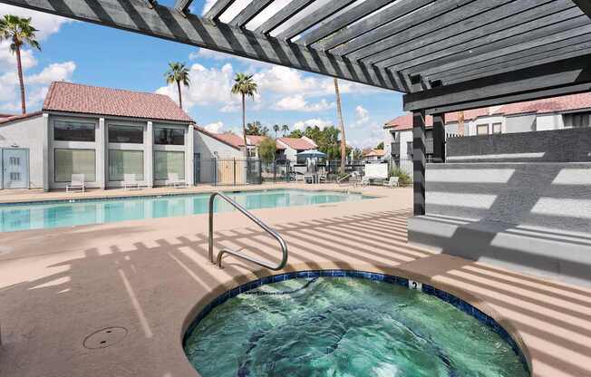 A pool with a metal railing and a building in the background.