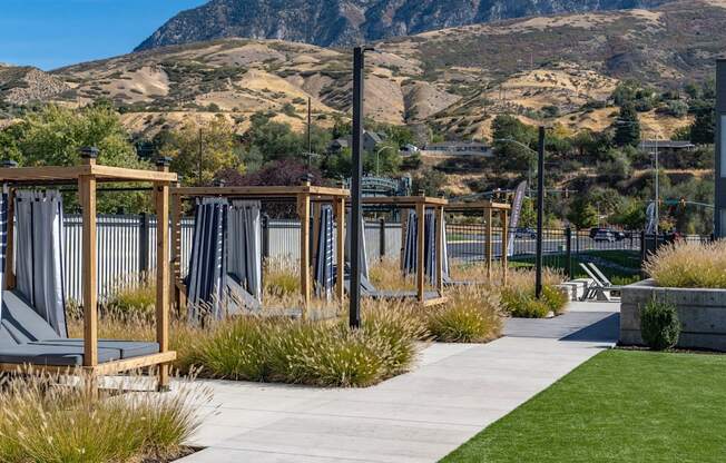 a view of the mountains from a park with benches and grass