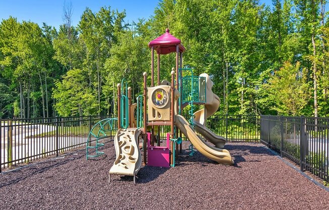 a playground with a swing set and slides in a park