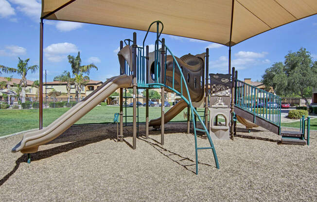 a playground with two slides and a climbing structure