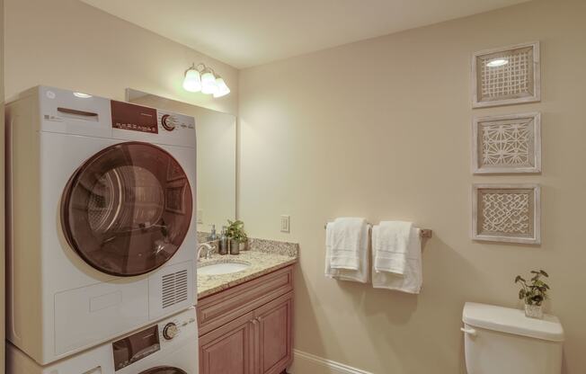 a washer and dryer in a bathroom with a sink and toilet