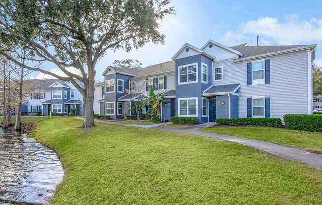 A row of houses with a tree in front of them.