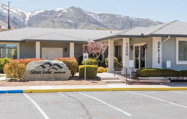 a building with mountains in the background in a parking lot