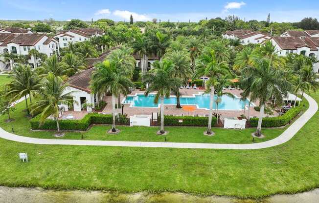 a mansion with a swimming pool surrounded by palm trees