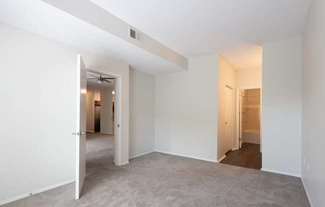 an empty living room with an open door to a closet