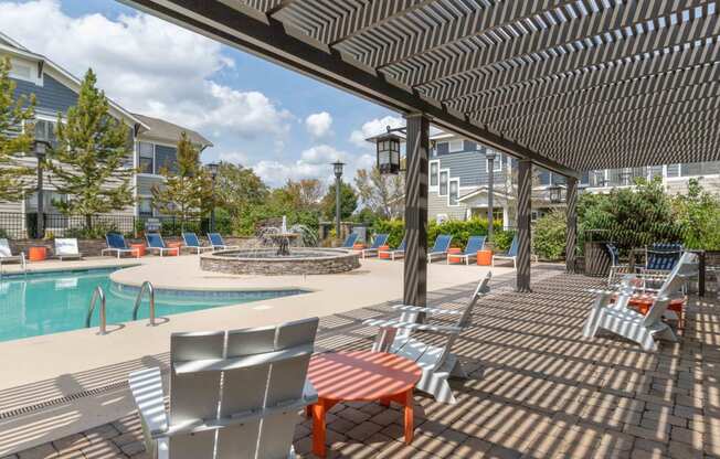 pergola covered seating area next to swimming pool