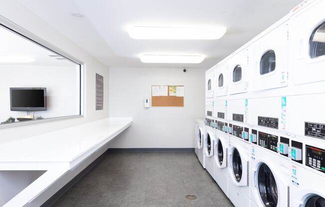 a laundry room with washers and dryers and a television