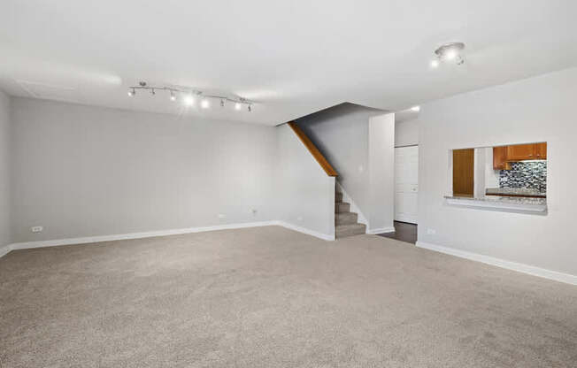 A spacious room with a staircase leading to another level.