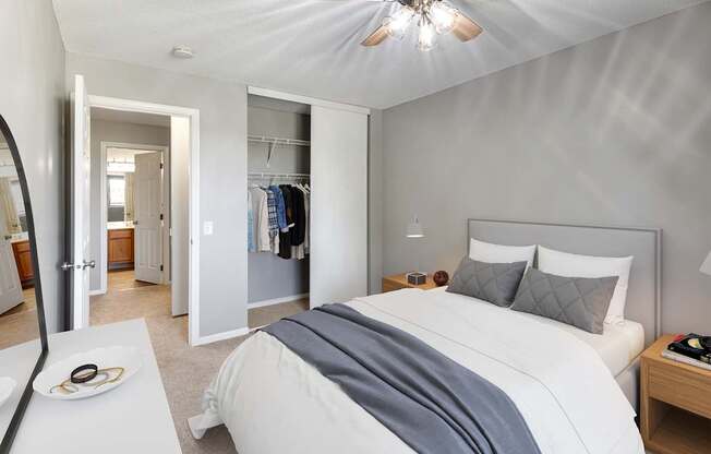 A bedroom with a large bed and a ceiling fan.