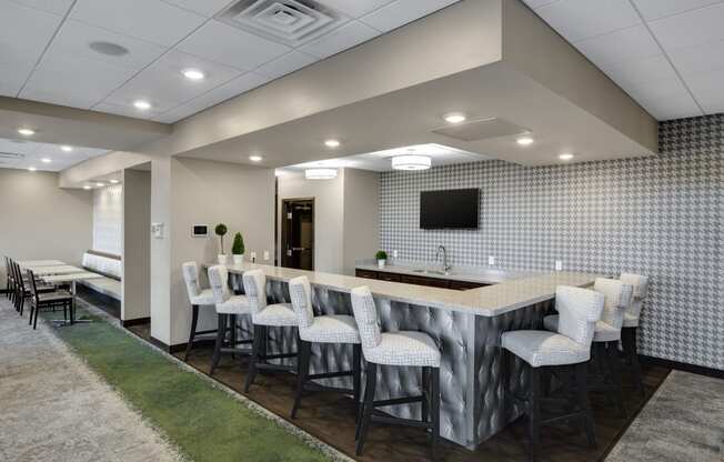 a room with a long table and chairs and a flat screen tv on the wall