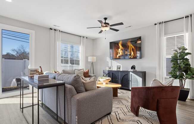 a spacious, furnished living room with large windows and glass doors to a private back yard in a home at Sanctuary at Indian Creek