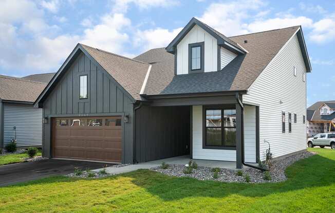 a house with a gray roof and a brown garage door