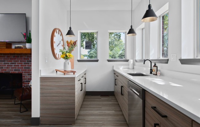 a kitchen with wooden cabinets and white counter tops and a sink