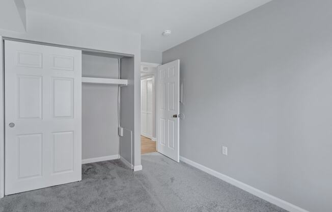 a bedroom with a closet and a door to a hallway