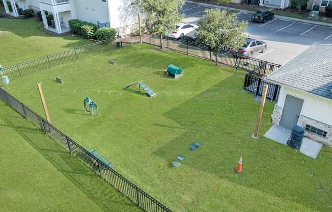 a backyard with a grass field and a yard with toys on it