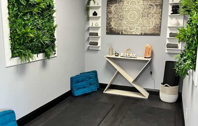 a room with a desk and plants on the wall