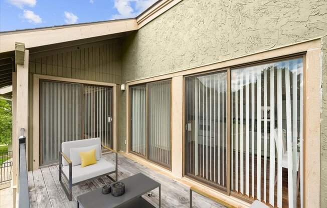 a balcony with two chairs and a coffee table