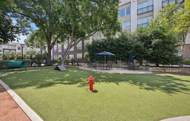 A red fire hydrant sits in the middle of a green lawn.