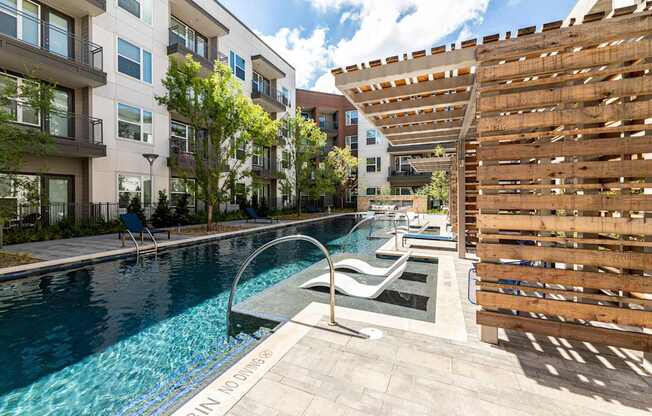 A pool with a slide and a wooden fence.