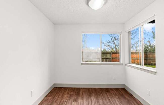 A room with a window and wooden flooring.