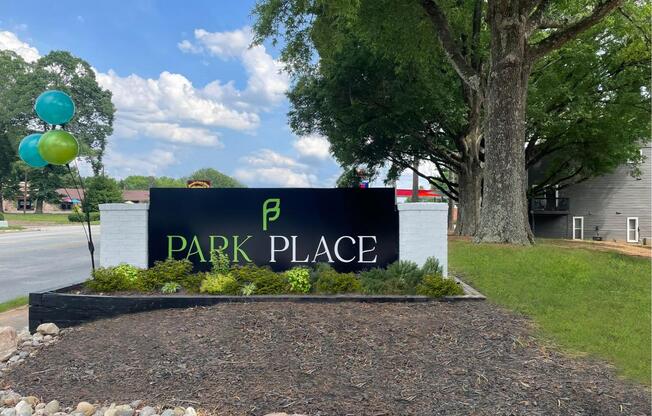 a sign that says park place in front of a tree