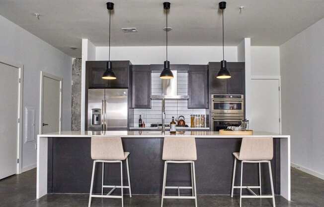 a kitchen with an island and three bar stools