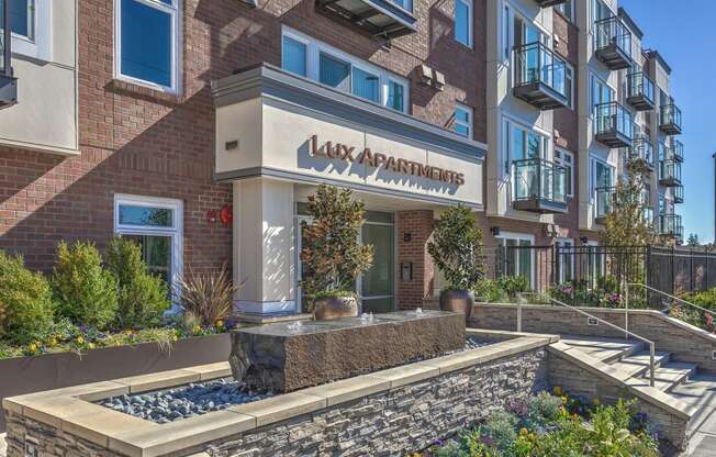 Lux Apartments Bellevue WA entryway with fountain and landscaped garden beds