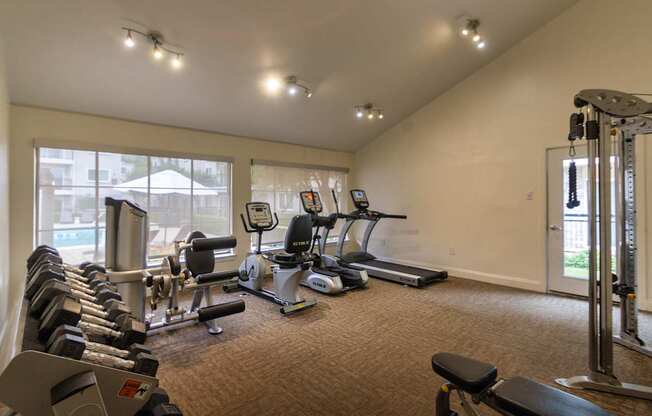 The 24-hour fitness center with treadmill, elliptical, free weights and other workout machines at The Summit at Midtown Apartments in Midtown, Dallas, TX.