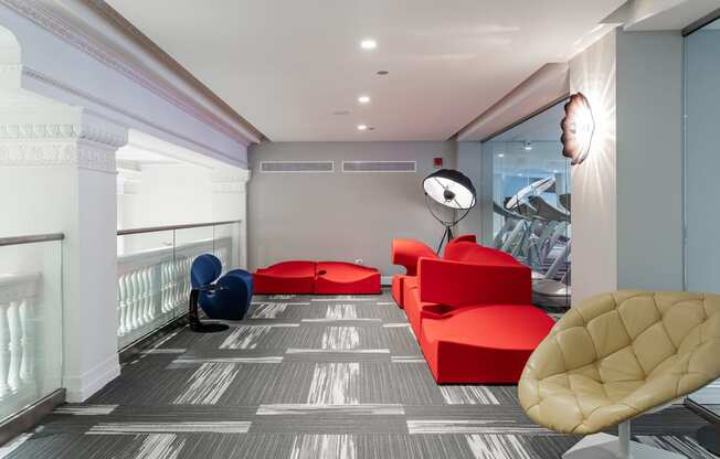 a living room with red furniture and a gray and white floor