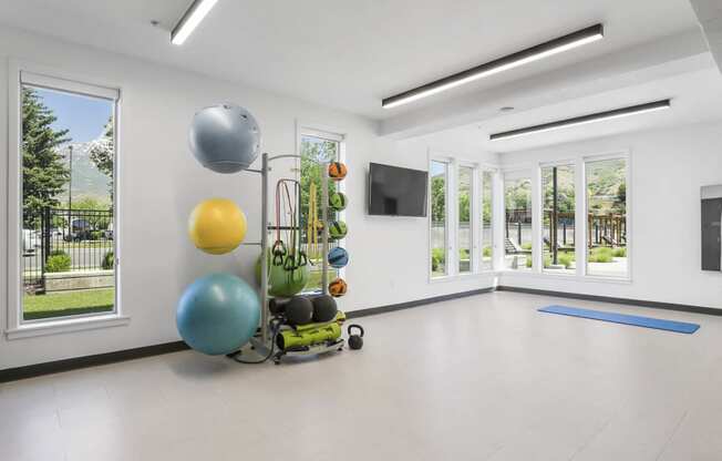 a large white room with white walls and white tile floors and a large window with a view at The Flats at Riverwoods, Provo, 84604