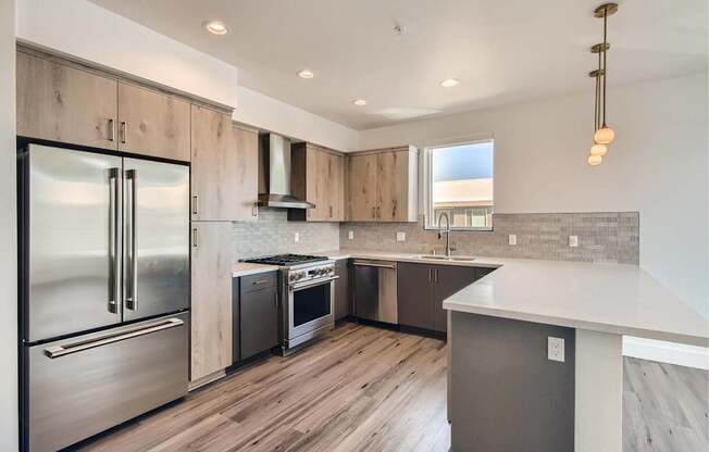 A modern kitchen with a stainless steel refrigerator and wooden cabinets.