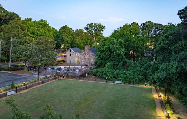 A large house is surrounded by a green lawn and trees. at Mill House at East Cobb, Marietta Georgia