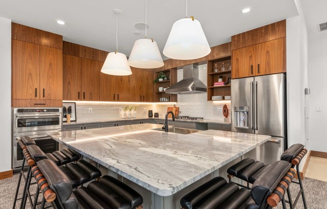 a large kitchen with a marble counter top and chairs at The Colony, North Carolina