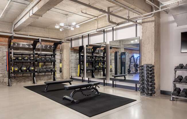 a gym with weights and dumbbells in a loft space