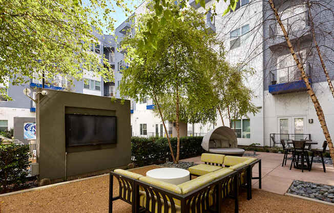 a living room with a tv and a table and a tree