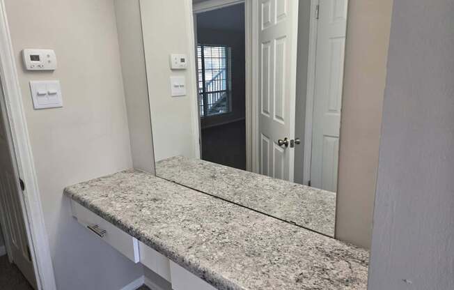 A bathroom with a granite countertop and a door.