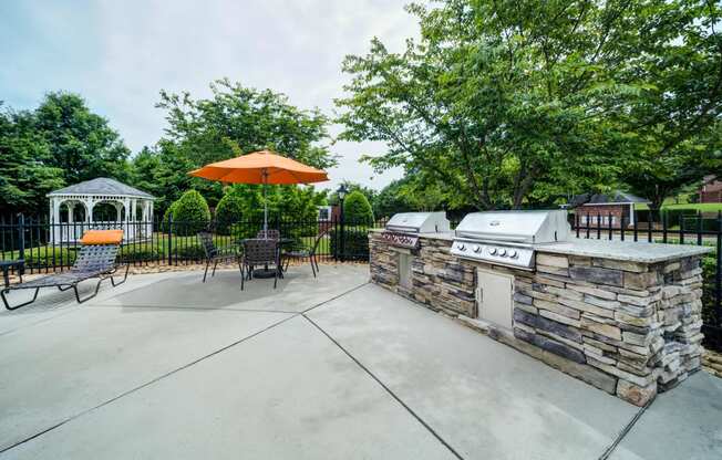 Umbrella Tables with Gas BBQ Grills adjacent to Pool Area and Gazebo