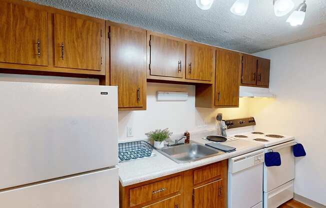 A kitchen with wooden cabinets and white appliances.