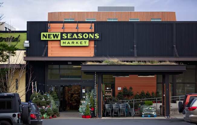 the front of new seasons market with cars parked outside