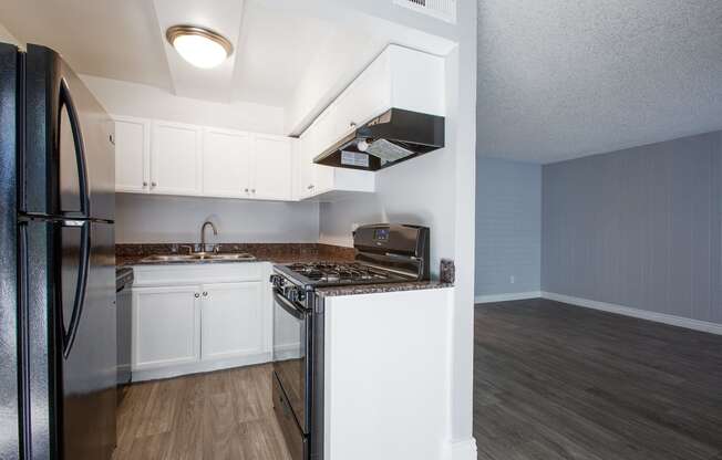 an empty kitchen with white cabinets and a stainless steel stove and refrigerator