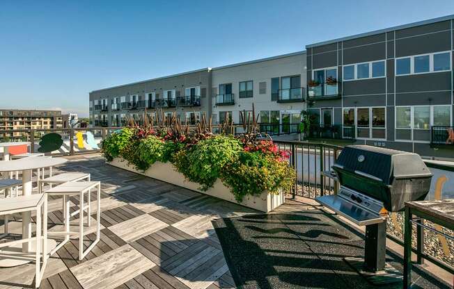 A patio with a table and chairs and a grill.
