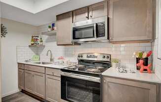 A modern kitchen with a stove, oven, and microwave.